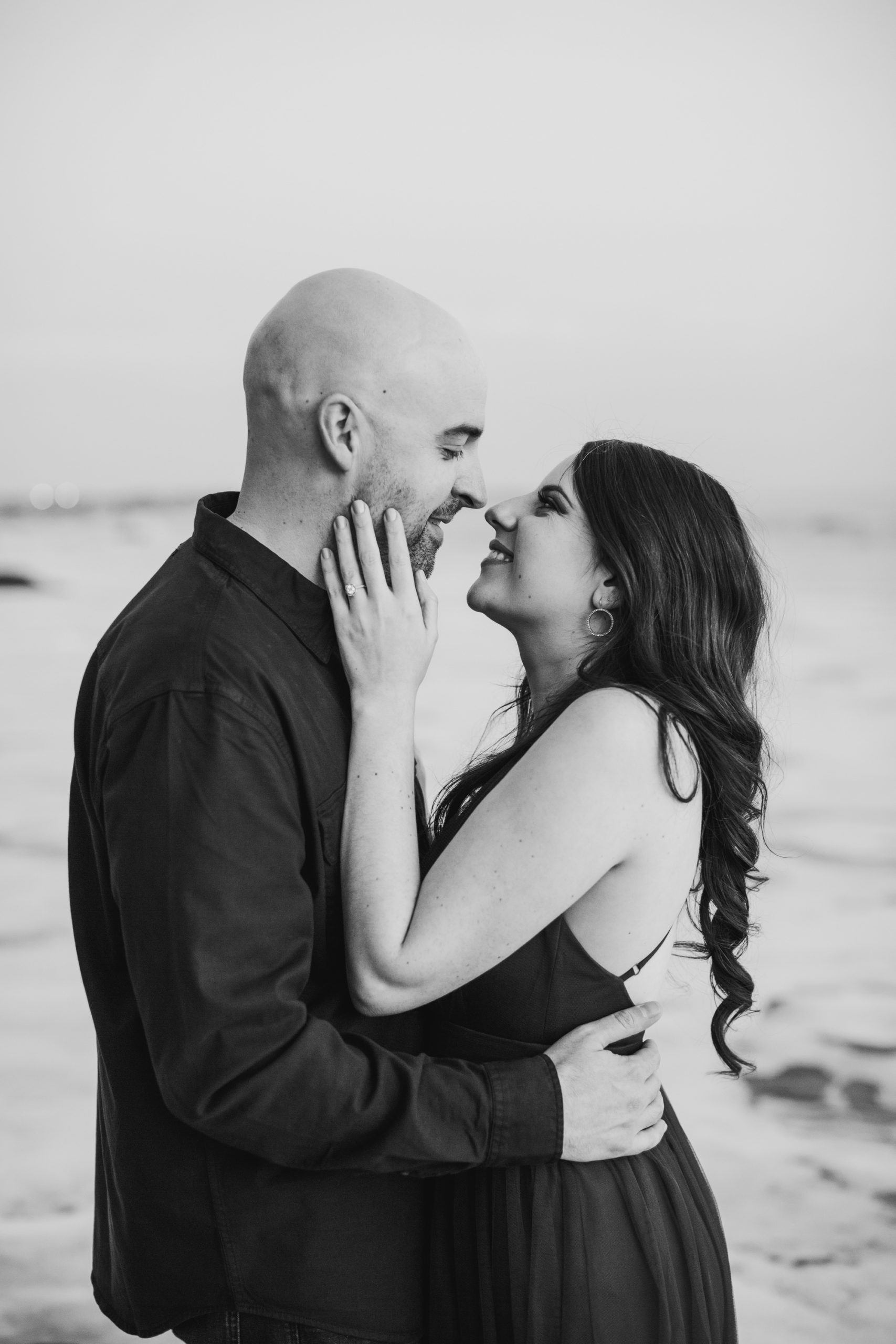 black and white close up of engagement photos. Young couple smiling at each other