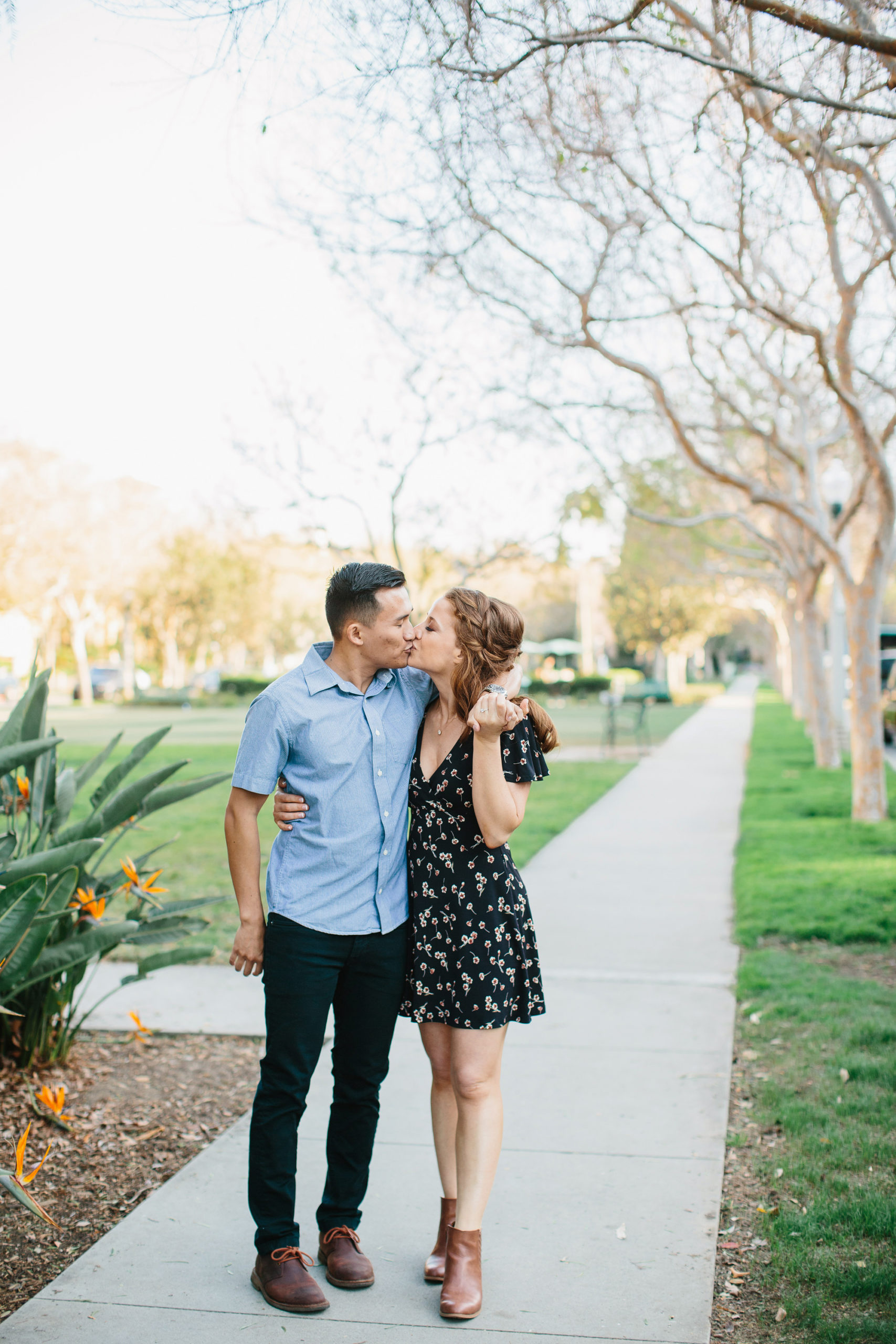 engagement photos in park of couple walking and kissing