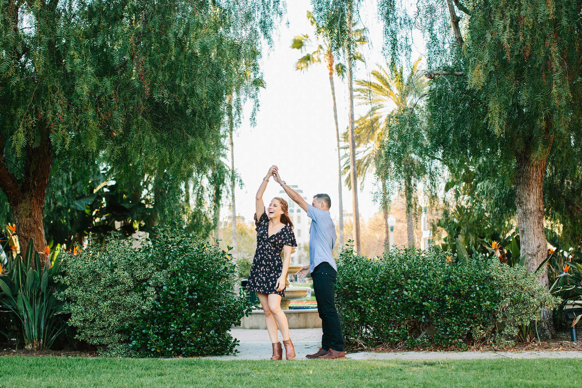 engagement photo in playa vista of couple dancing in a park and twirling